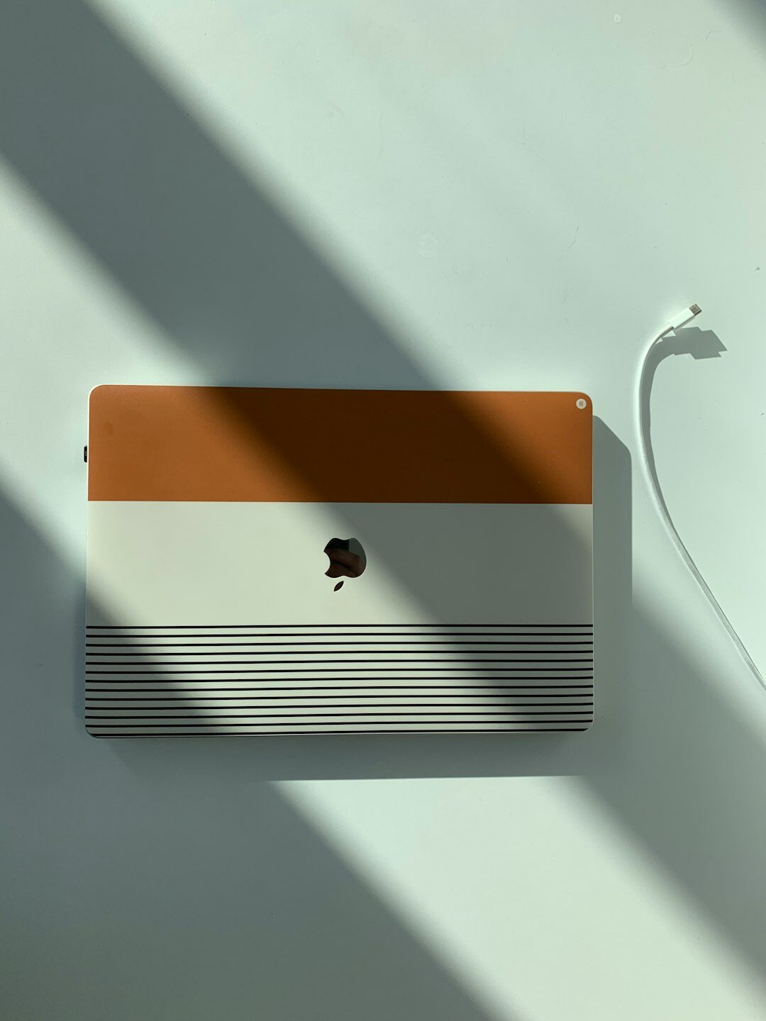 Notebook, pen and laptop on a wooden desk with soft light